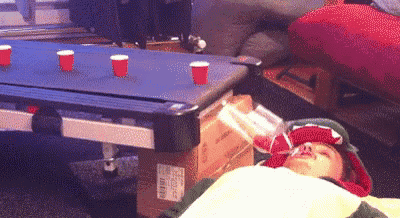 a person is laying on a bed with a pool table in the background .