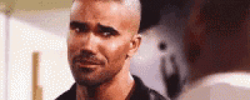 a man with a shaved head and a beard is making a funny face and smiling .