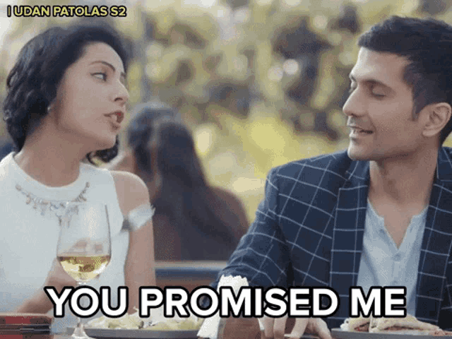 a man and a woman are sitting at a table and the woman says you promised me