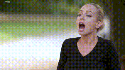 a woman is screaming with her mouth wide open .