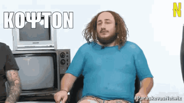 a man in a blue shirt is sitting in front of a stack of old televisions with the word koyton written above him