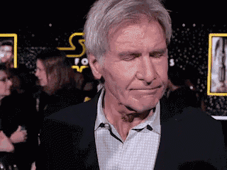 a close up of a man 's face with a star wars sign in the background .