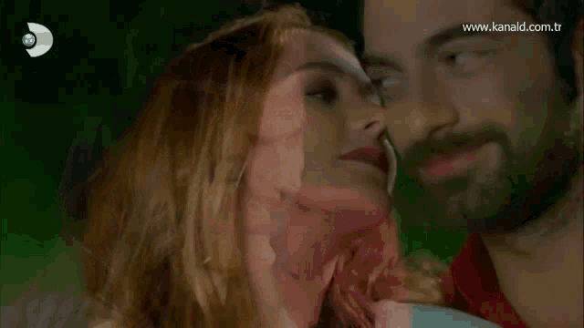 a man and a woman are kissing in front of a screen that says www.kanald.com.tr on it