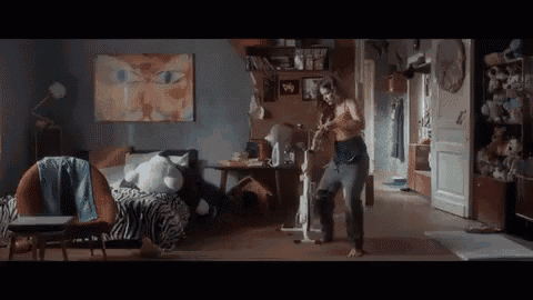 a woman is standing in a bedroom next to a bed