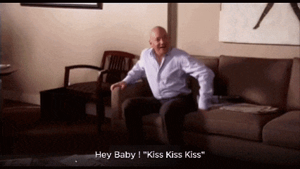 a man is sitting on a couch and saying hey baby