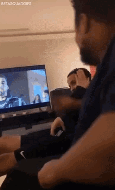 a man is sitting in front of a tv with the hashtag betasquadgifs at the bottom