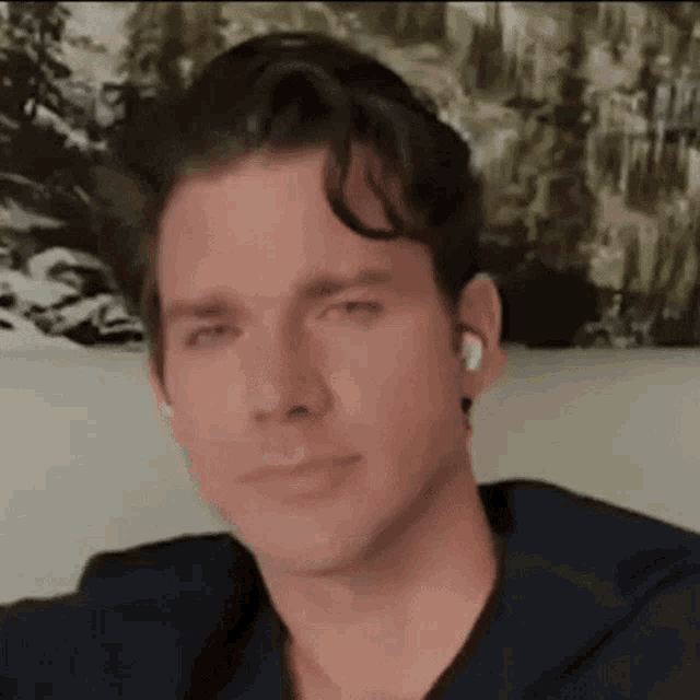 a man wearing ear buds is sitting on a couch .