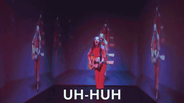 a woman singing and playing a guitar with the words uh-huh above her