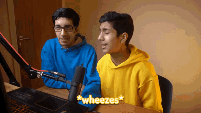 a man in a yellow hoodie says " wheezes " while another man in a blue sweatshirt looks on
