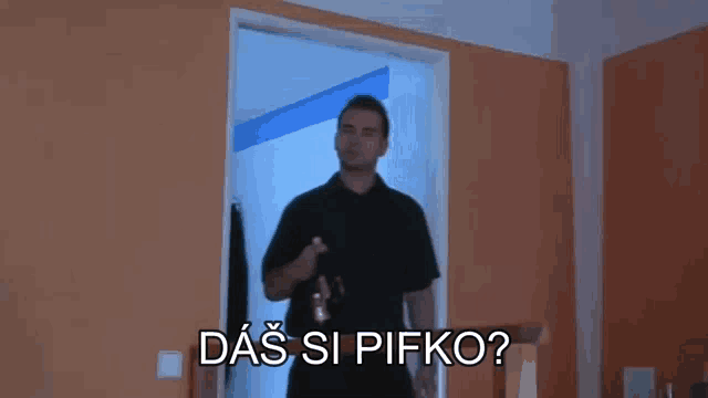a man in a black shirt is standing in a doorway holding a bottle of beer and asking a question .