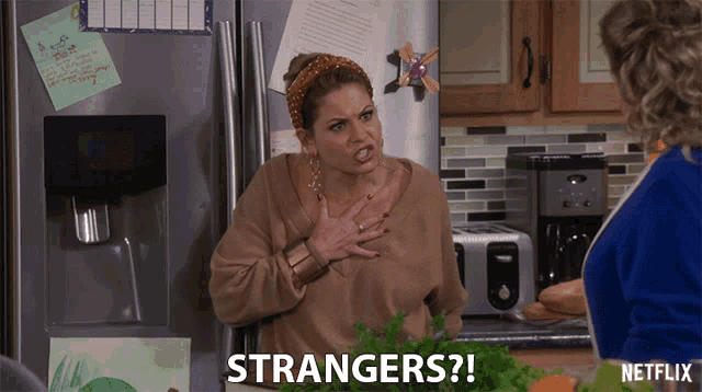 a woman in a kitchen with strangers written on the counter