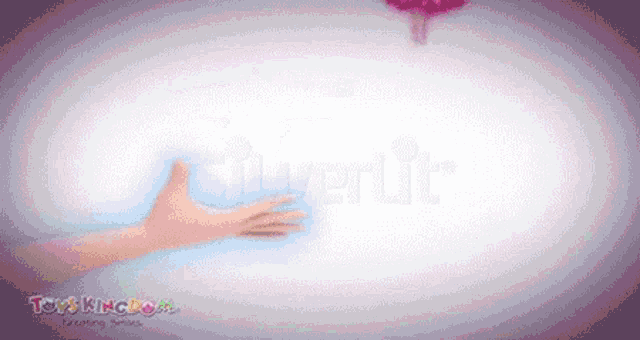 a blurred image of a hand reaching out to a toys kingdom logo
