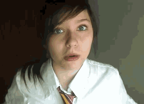 a girl wearing a white shirt and a tie looks surprised