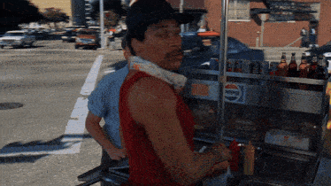 a man is standing in front of a pepsi cart