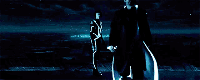 a man and a woman are standing in a dark room