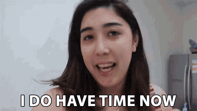 a woman says i do have time now in front of a refrigerator .