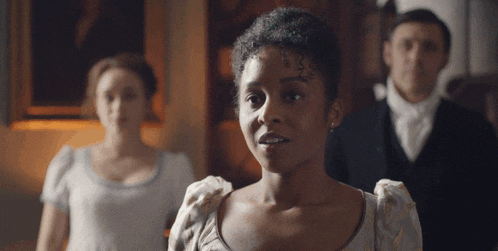 a woman stands in front of a group of people