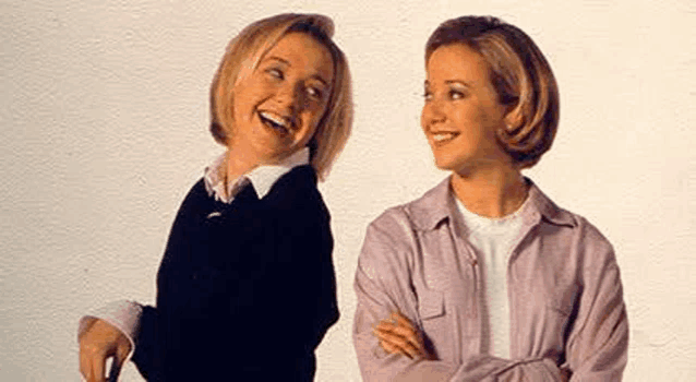 two women are standing next to each other with their arms crossed .