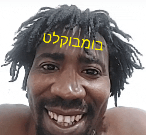 a man with dreadlocks and a beard is smiling with a yellow sticker on his head