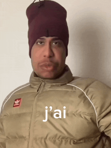 a man wearing a beanie and a jacket that says j'ai on it