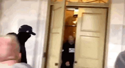 a group of people are standing in front of a door .