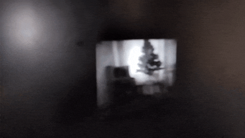 a dark room with a shadow of a person hanging from the ceiling