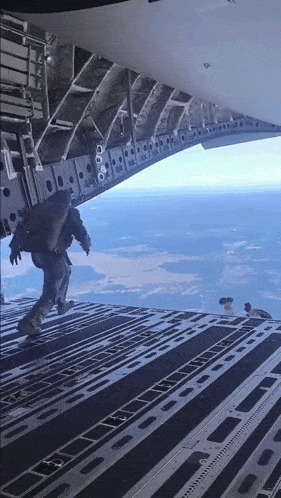 a man is walking out of a plane with a bag on his back that says ' a ' on it