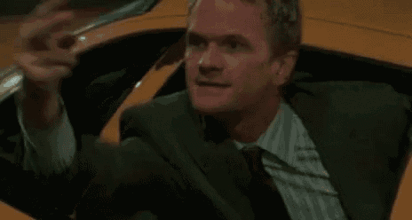 a man in a suit and tie is talking on a cell phone while sitting in a taxi cab .