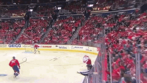 a hockey game is being played in a stadium with advertisements for dunkin ' and leidos