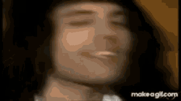 a close up of a person 's face with their eyes closed and a cigarette in their mouth .