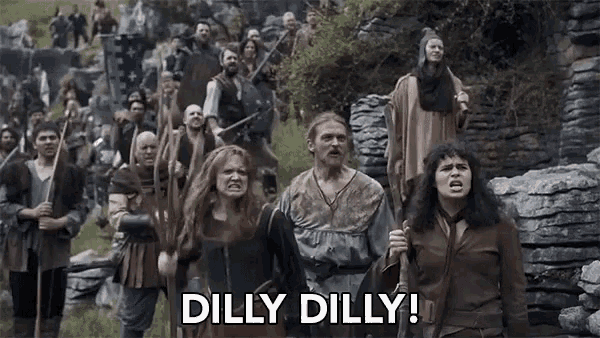 a group of people are walking in a field with the words dilly dilly written on the bottom .