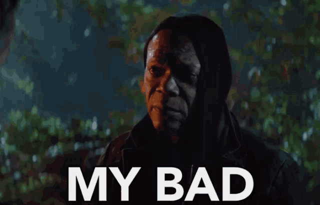 a man in a hooded jacket holds a cell phone in front of the words my bad