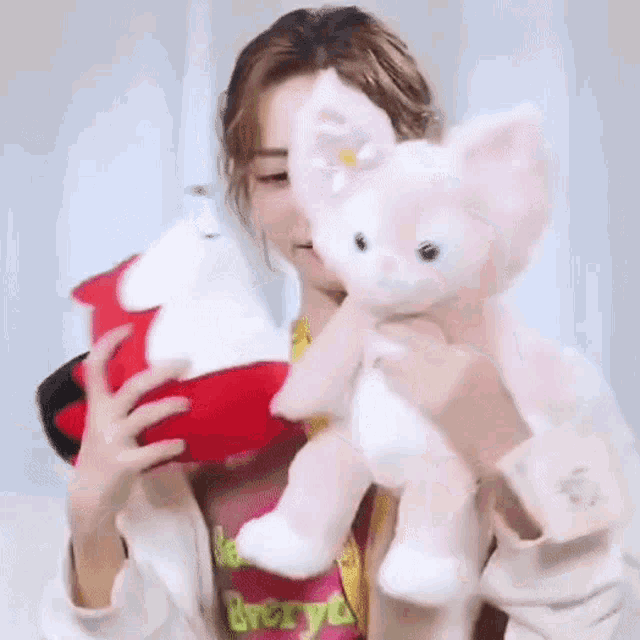a woman is holding a stuffed animal and a stuffed animal .