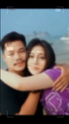 a man and woman are hugging each other in a blurry photo .