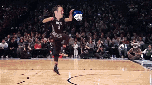 a basketball player with the number 8 on his jersey kicks a ball