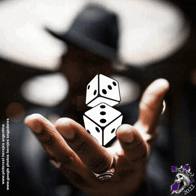 a man in a hat holds two dice in his hand