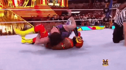 two wrestlers are wrestling in a wrestling ring with a referee watching .