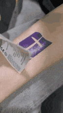 a person is getting a temporary tattoo on their arm .
