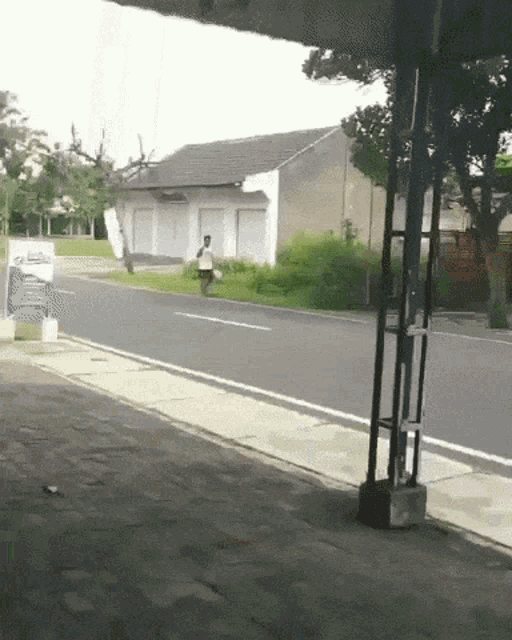 a man walking down a street with a sign in the background that says ' aa '