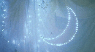 a crescent moon and a star are hanging on a white curtain .