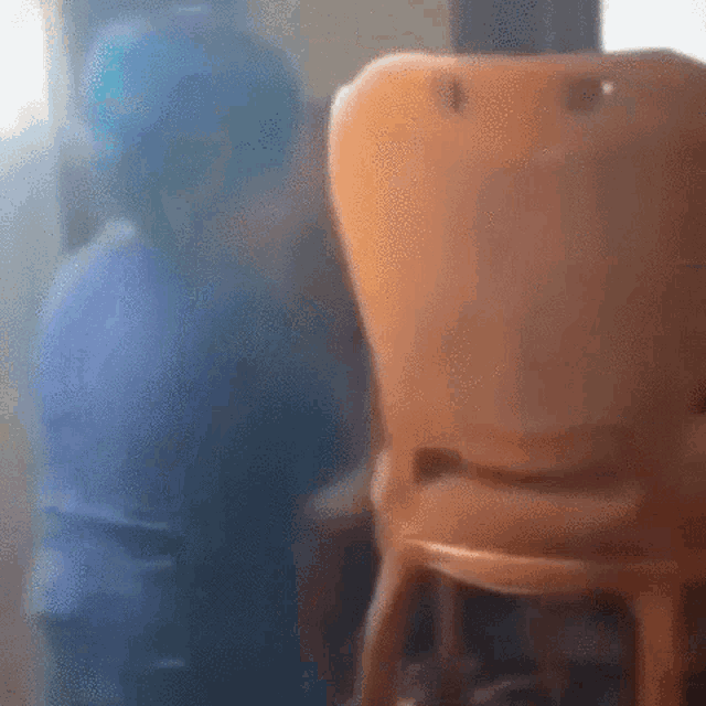 a blurry picture of a person sitting in a chair in front of a mirror .