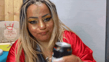a woman in a red robe is holding a can of diet pepsi