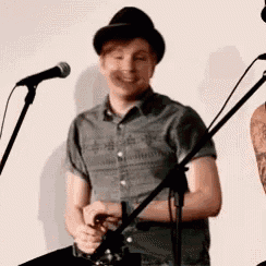 a man in a hat is singing into a microphone .