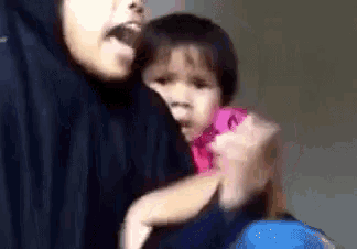 a woman is holding a little girl in her arms