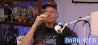 a man is sitting in front of a microphone with a sign that says dark web on the bottom