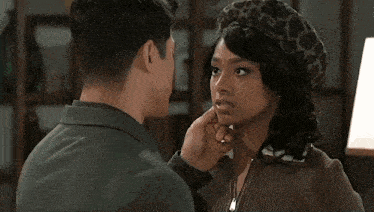 a man and a woman are kissing with the woman wearing a leopard print hat