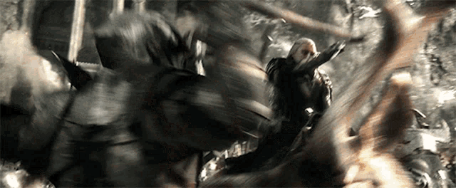 a blurry picture of a man riding a horse in a forest