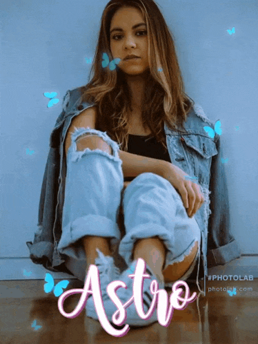 a woman in a denim jacket sits on the floor with the word astro on the bottom