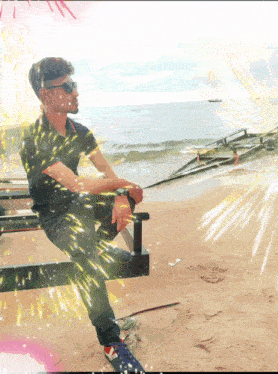 a man sitting on a bench on the beach with a boat in the background