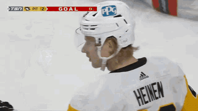 a hockey player with the number 12 on his helmet talks to another hockey player
